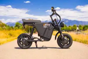 EMOVE RoadRunner Pro V2 electric moto parked on a path with snow-capped mountains behind